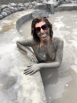 Woman in hot tub of mud